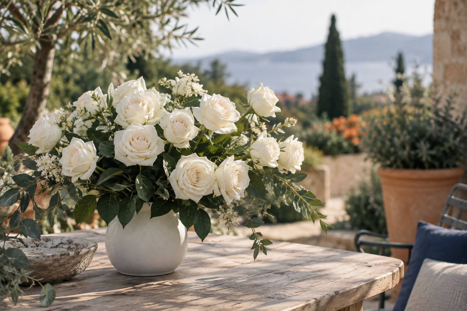 Bouquet de roses blanches sur une table en bois clair avec vase en céramique